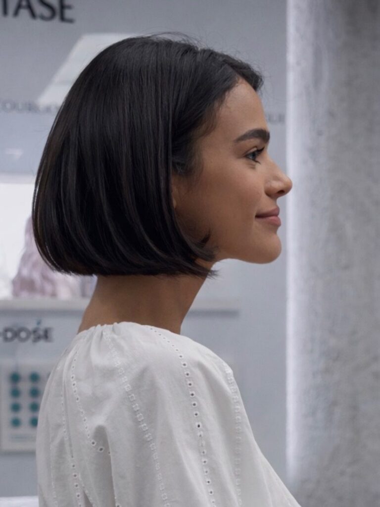 Woman showing a sleek chin-length dark bob haircut in profile