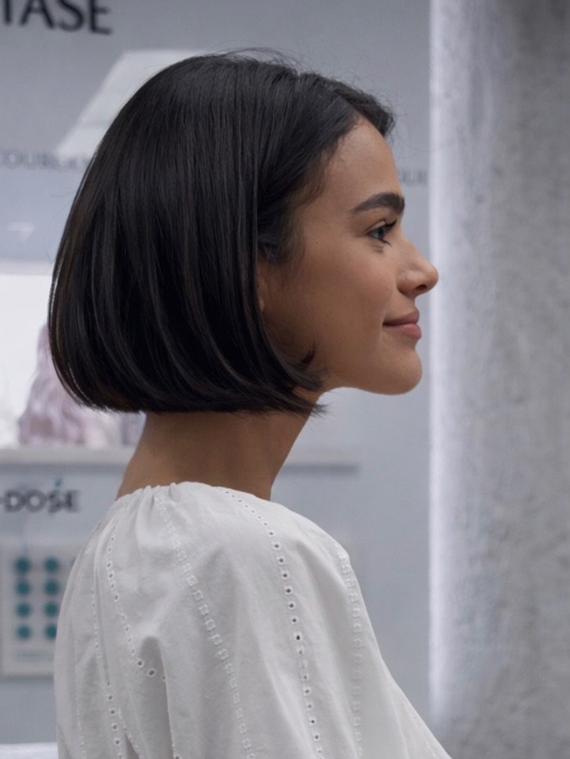 Woman showing a sleek chin-length dark bob haircut in profile