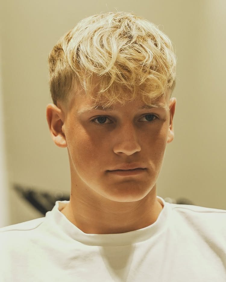 Young man with a gradual taper and curly French crop fringe