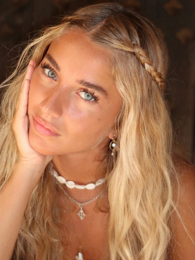 Young woman with long blonde beachy waves and a braid across her crown