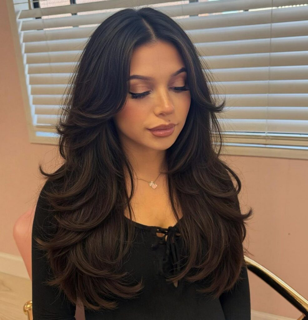 Woman with long dark hair styled in loose, flowing waves