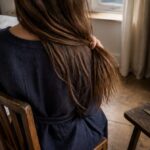 Long dark hair beside styling tools and hair care products