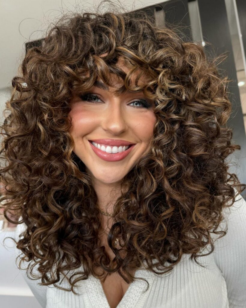 Woman showing long, voluminous brown curls with soft face-framing layers