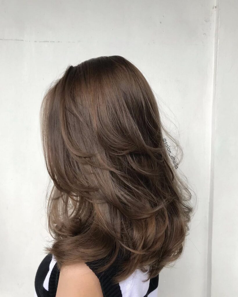 Medium brown layered haircut with glossy, curled feathered ends