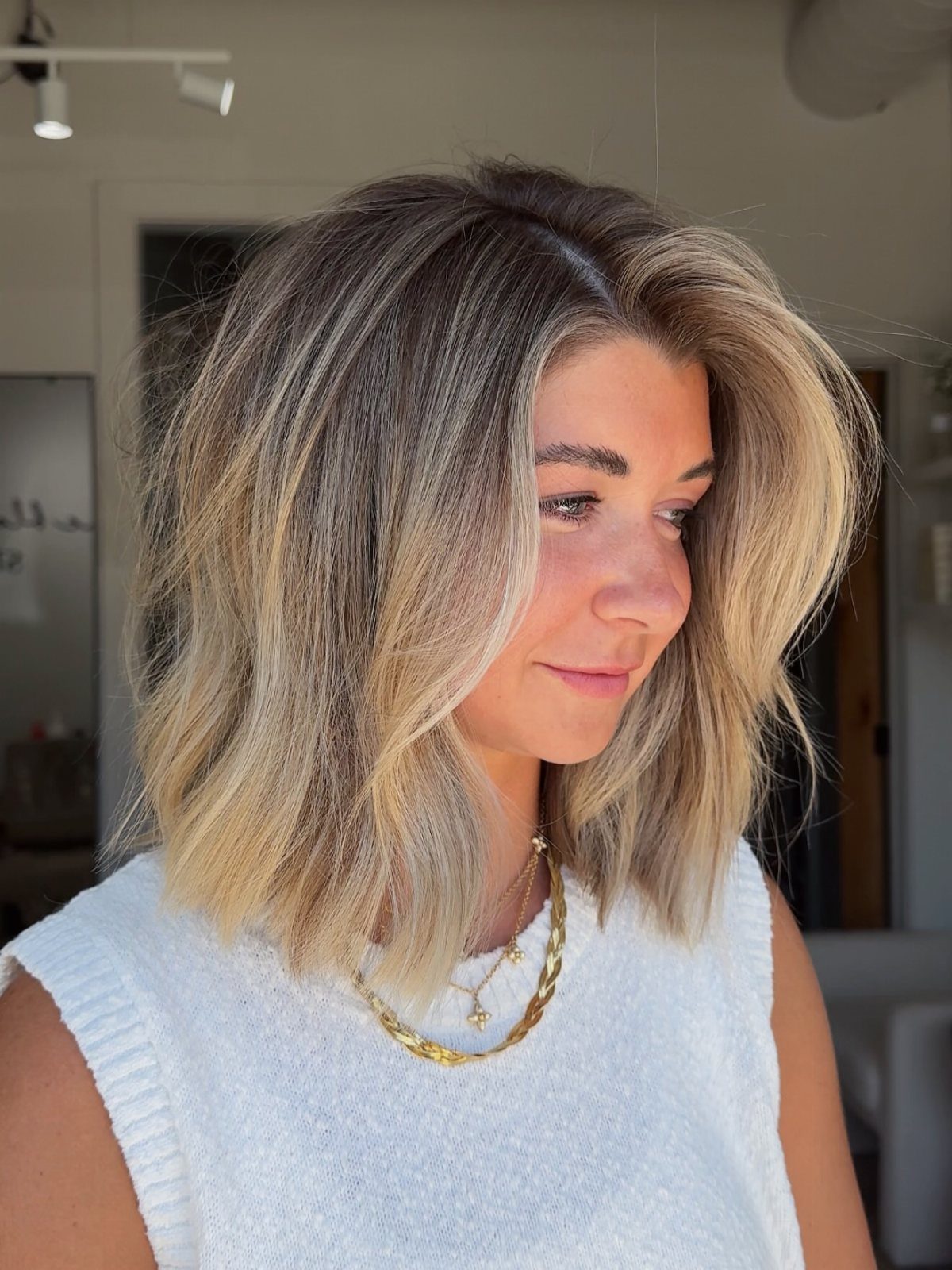 Woman showing a shoulder-length blonde textured bob with soft waves and layered ends