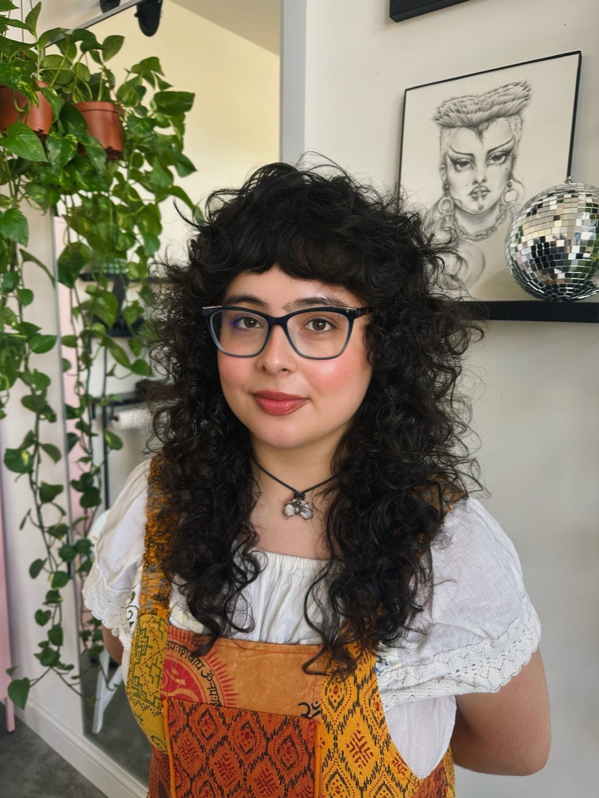 Person showcasing a voluminous curly shag haircut with bangs indoors