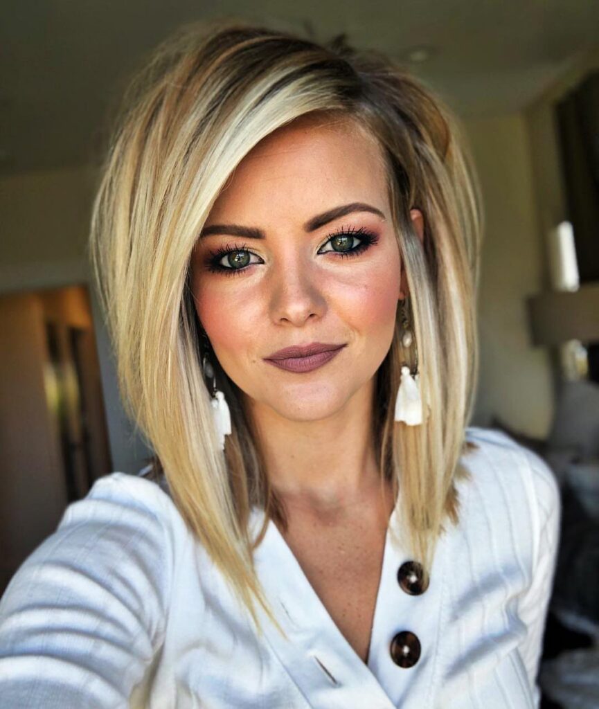 Woman with straight blonde shoulder-length hair and a side part